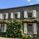 volets battants blanc sur maison en pierres