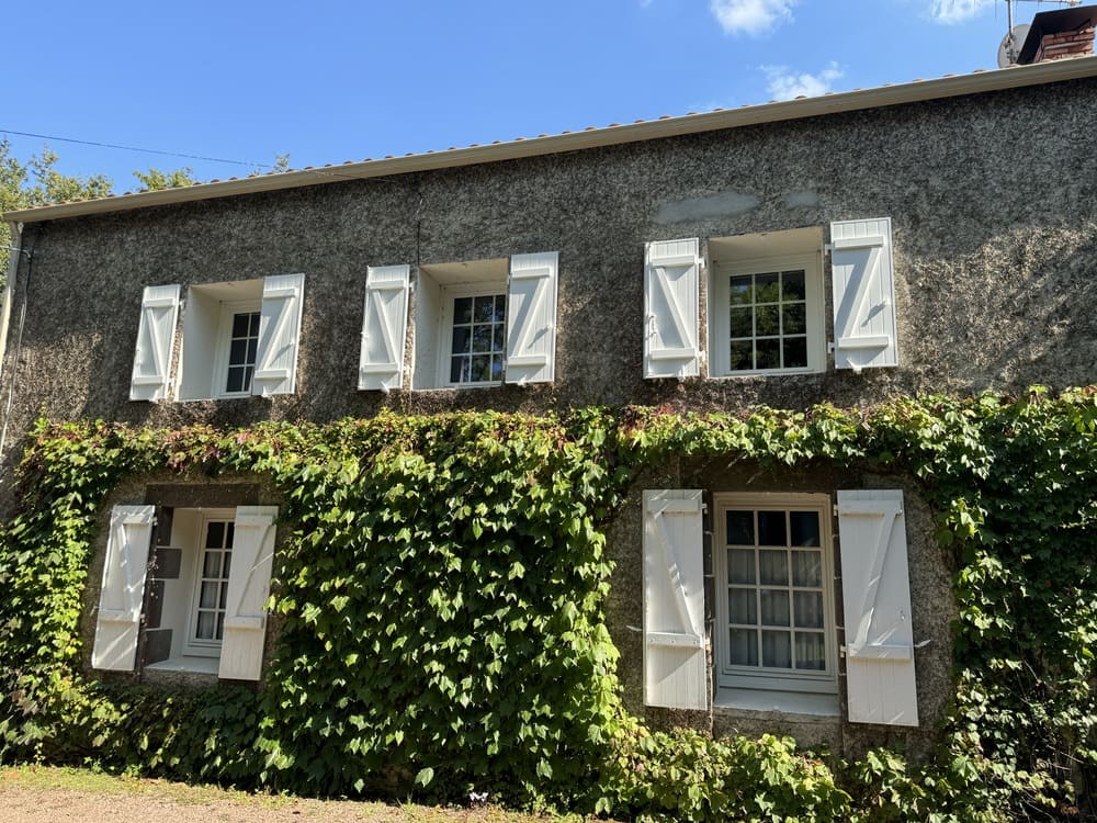 volets battants blanc sur maison en pierres
